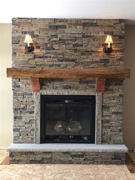 A Stone Fireplace With Two Lights On Each Side