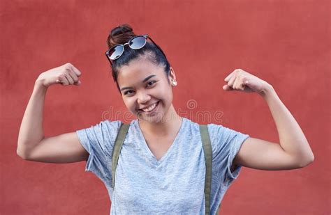 Smiling Young Asian Woman Humorously Flexing Her Arms Outside Stock