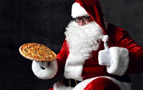 Santa Claus Is Holding Tasty Pizza On His Open Palm Showing Thumb Up