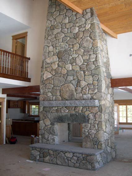 pass through fieldstone fireplace with antique granite lintel and swenson gray granite mantel