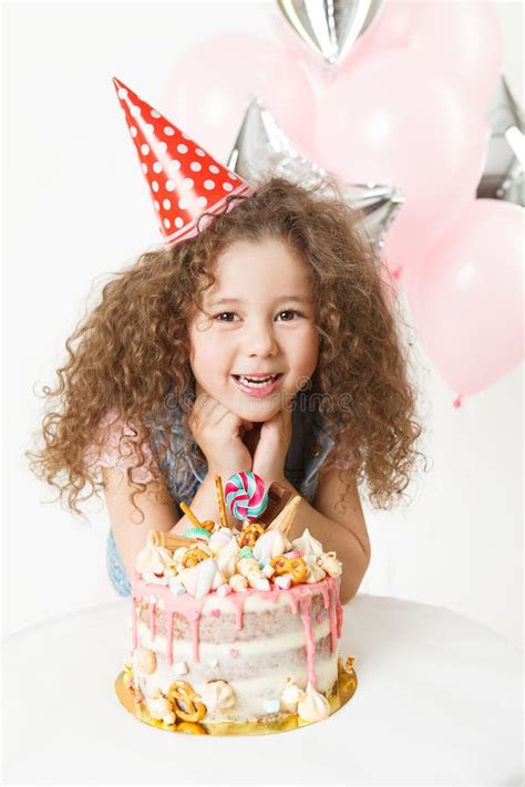 Celebration Happy Little Curly Girl In Festive Cup Sit Near Birthday Cake And Smiling Stock