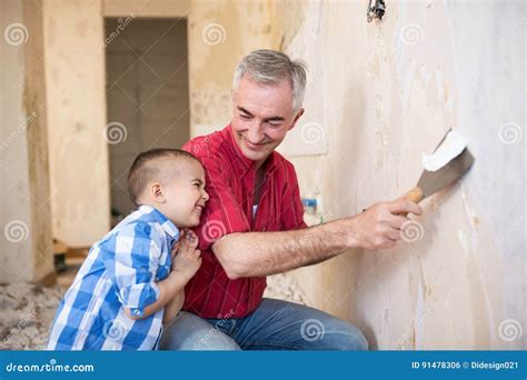 Grandpa Takes Off Wallpaper And Laughing With His Grandson Royalty Free