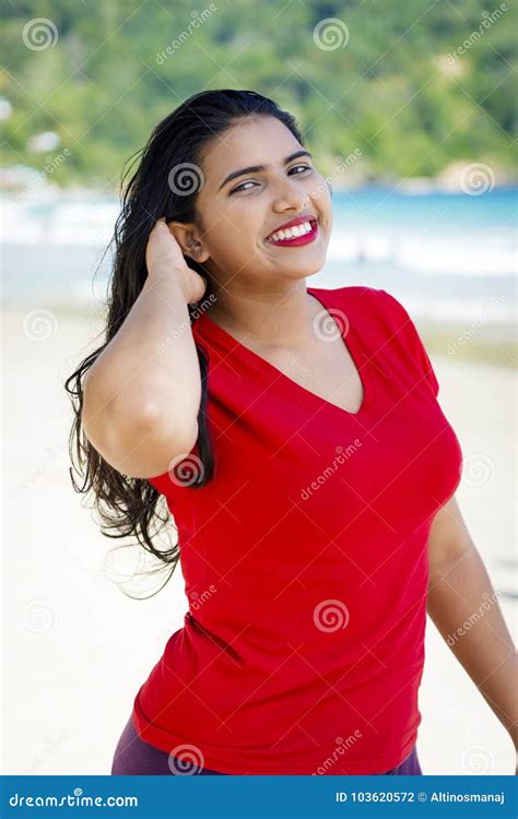 muchacha feliz de la mujer joven con una sonrisa grande por la playa que disfruta de la sol
