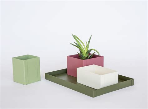 Three Different Colored Planters Sitting Next To Each Other On Top Of A