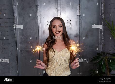 Beautiful Girl With Long Curly Hair Smiles Holds Bright Sparklers In Hands With Professional