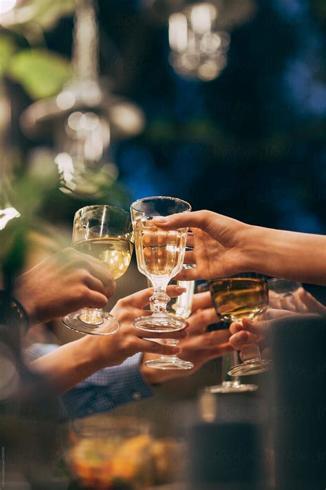 Hands Of Group Of People Toasting With Crystal Glasses At Outdoor Party