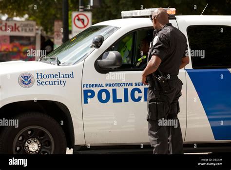 Homeland Security Police Officer Standing Next To Cruiser Stock Photo