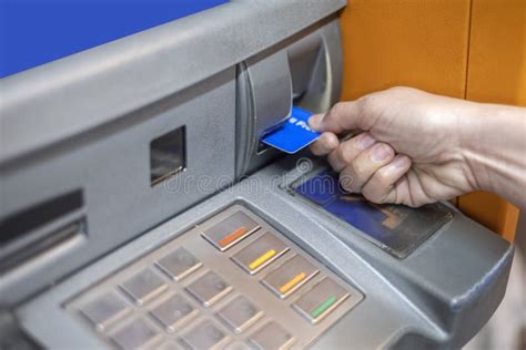 Hand Inserting Atm Card Into Atm Bank Machine For Withdrawing Money