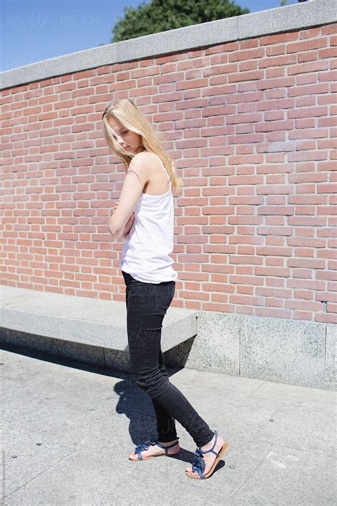 Girl Walking Near A Brick Wall Del Colaborador De Stocksy Michela