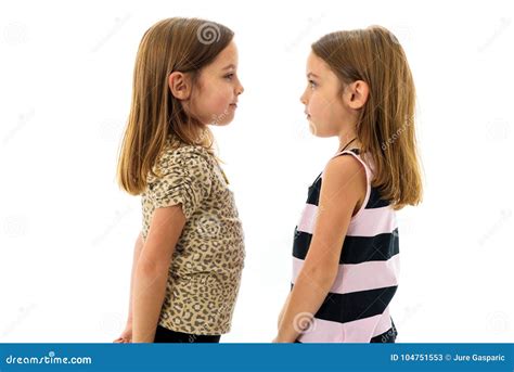 Identical Twin Girls Are Looking At Each Other And Smiling Stock Image