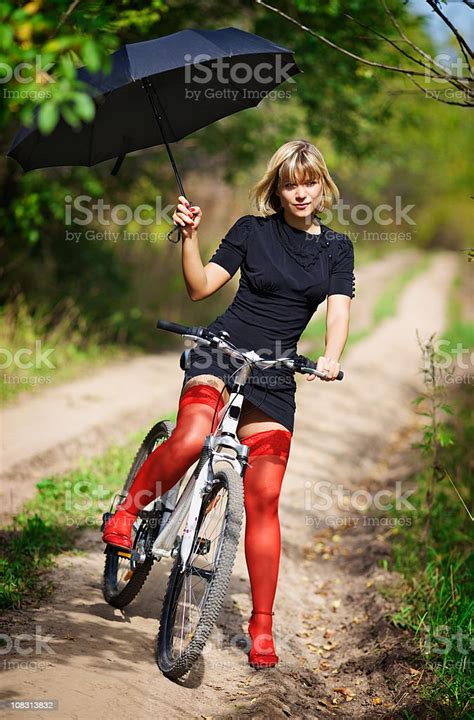 Blonde In Red Stockings On A Bicycle With An Umbrella Stock Photo