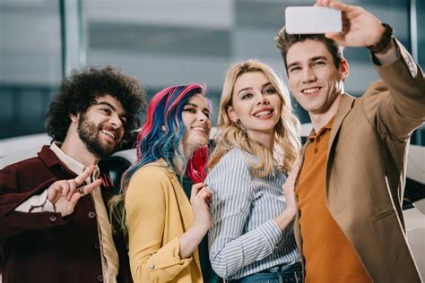 Cheerful Group Of Friends Smiling While Taking Selfie On Smartphone