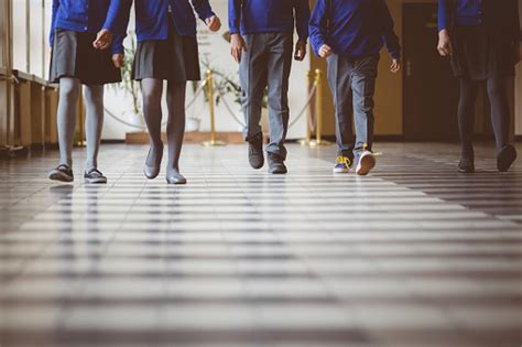 Group Of Students Walking Through School Hallway Stock Photo Download