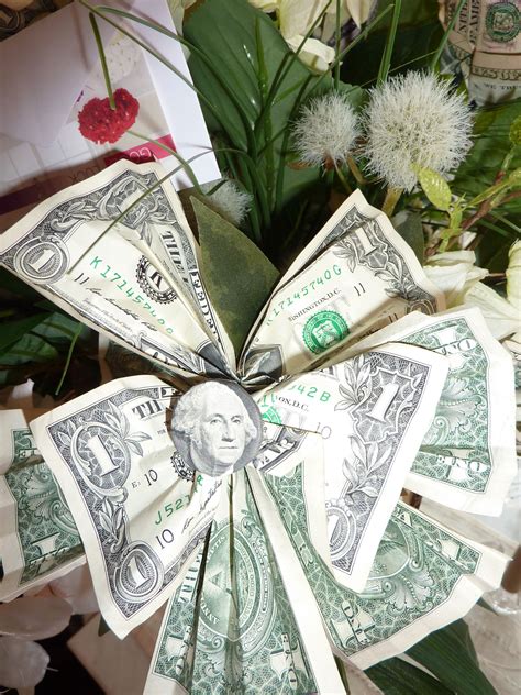 Dollar Bills Are Arranged In The Shape Of A Fan On Top Of Some White