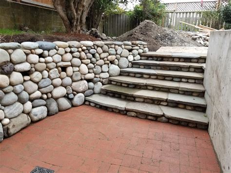 River Rock Wall With Plant Pockets Bluestone Steps And Red Brick