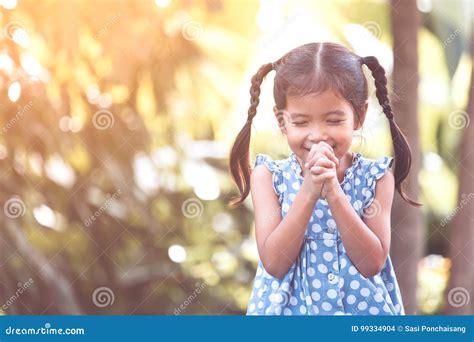 Cute Asian Little Child Girl Praying With Folded Her Hand Stock Photo