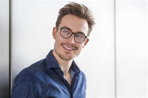 Portrait Of Smiling Young Man Wearing Glasses Stock Photo