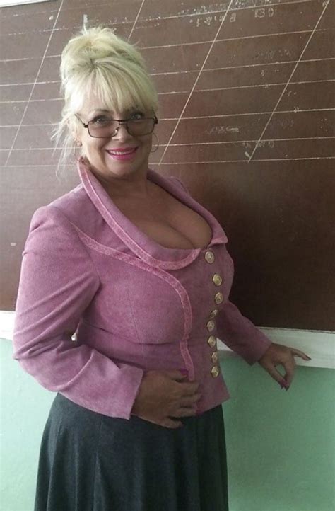 a woman standing in front of a chalkboard with her hands on her hips and wearing glasses