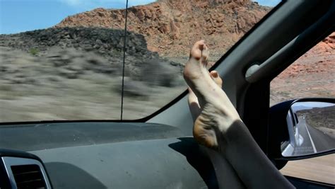 Woman Feet Barefoot On Car Dashboard Driving On A Highway In Spain