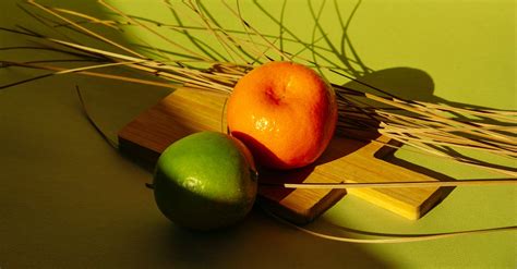 Green And Orange Round Fruit On Brown Wooden Board · Free Stock Photo