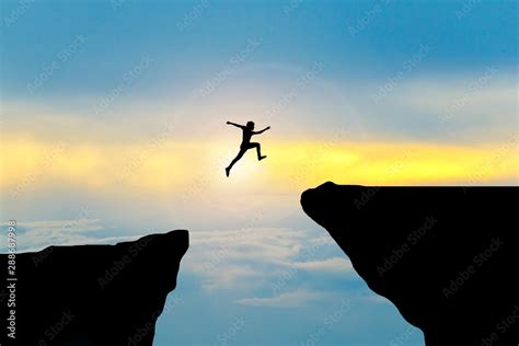 Man Jump Through The Gap Between Hillman Jumping Over Cliff Stock
