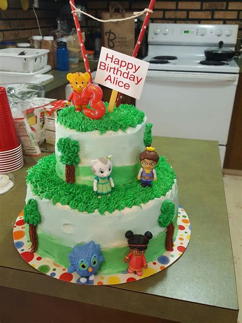 A Three Tiered Birthday Cake Decorated With Characters