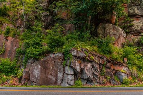 Roadside Rocks A Rocky Outcropping Hugs The Side Of A Road In The