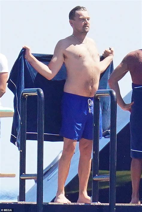 leonardo dicaprio shows off his shirtless physique in navy swimming trunks as he soaks up the