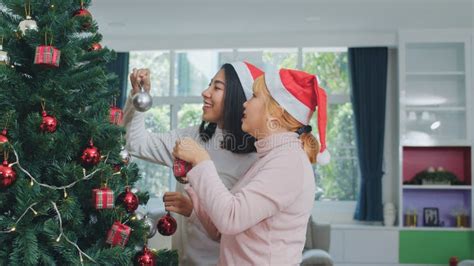 Asian Women Friends Decorate Christmas Tree At Christmas Festival
