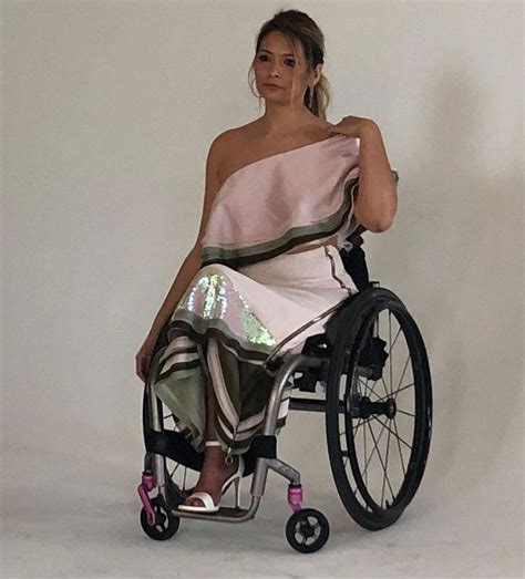A Woman In A Wheelchair Poses For The Camera With Her Hand On Her Hip And One Leg Up