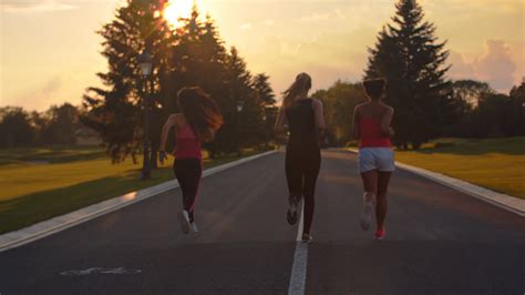Group Of Women Running At Sunset Back View Of Three Fitness Women