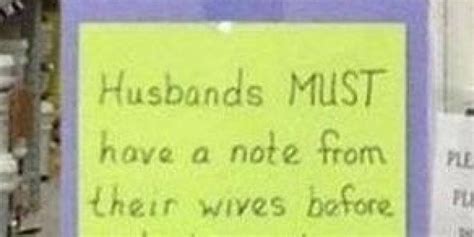 A Sign Posted On The Side Of A Building That Says Husbands Must Have A Note From Their Wives