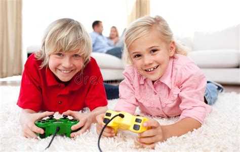 Siblings Playing Video Games Together Stock Photo Image Of Lying