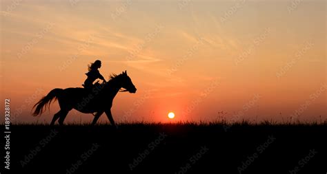 Horseback Woman Riding On Galloping Horse With Red Rising Sun On