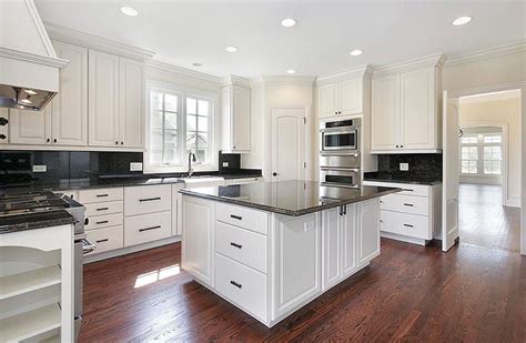 Kitchen With White Cabinets And Black Granite Countertops With Wood