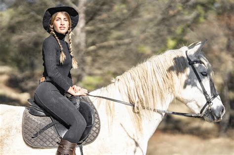 Portrait Of Woman Horseback Riding In Paddock Stock Photo