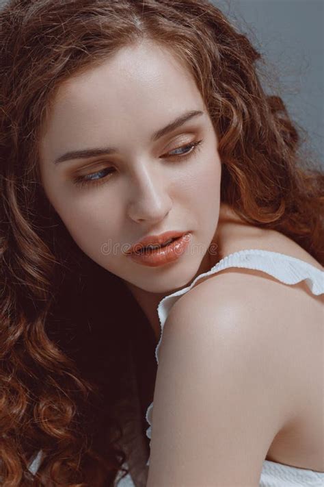 Portrait Of Beautiful Young Woman With Curly Hair Looking Away Stock