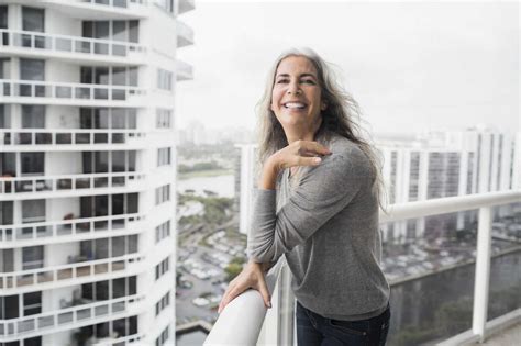 Portrait Of Happy Mature Woman Standing On Balcony Stockphoto