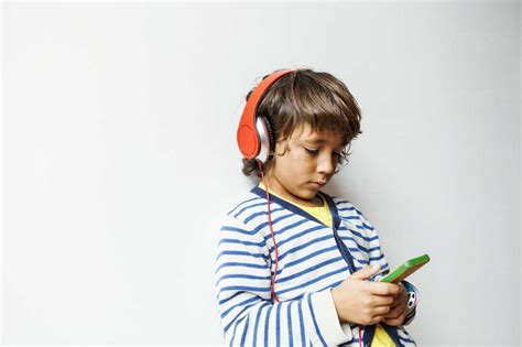 Little Boy Listening To The Music Of His Smartphone With Headphones