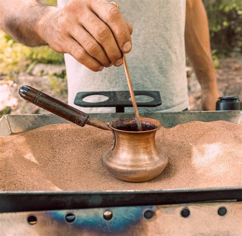 The Process Of Making Turkish Coffee On Hot Sand In A Turk With Male