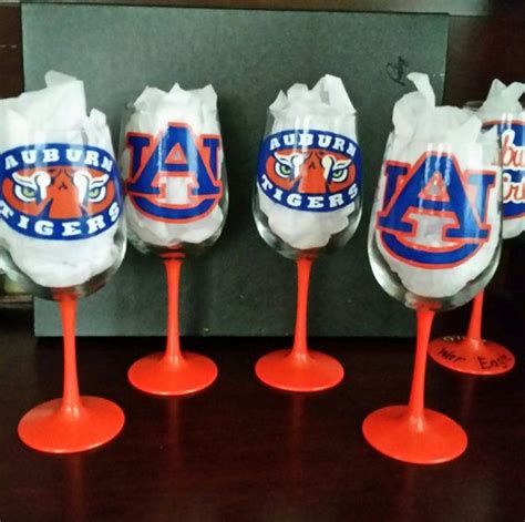 Four Wine Glasses With Auburn University Logos On Them Sitting On A Table Next To Each Other