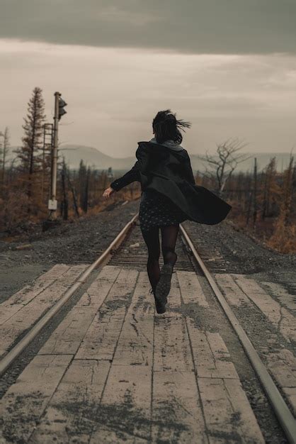 Premium Photo Rear View Of Woman Walking On Railroad Track