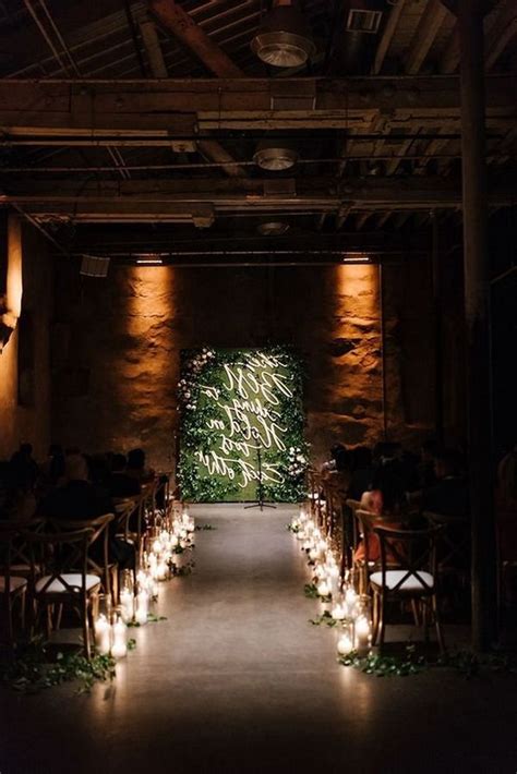 The Aisle Is Lined With Candles And Greenery