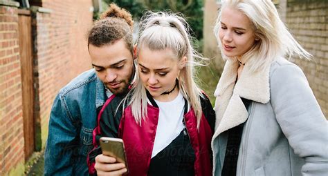 Three Teenagers Using Their Phones Del Colaborador De Stocksy Kkgas Stocksy