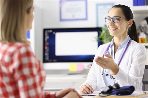 Doctor sonriente hablando con el paciente en la mesa en el concepto de gestión del embarazo de