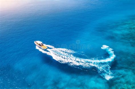 Aerial View Of The Speed Boat In Clear Blue Water At Sunset Stock Photo