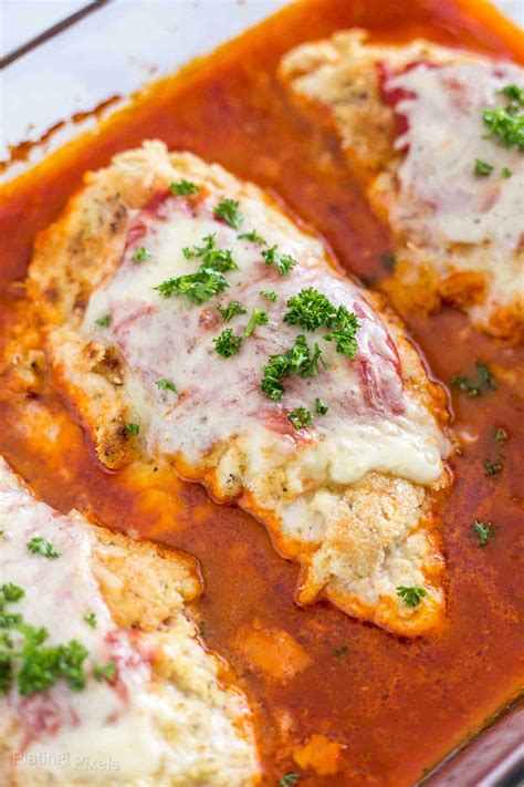 Season chicken outside and inside with salt, pepper and parsley. Close up shot of Baked Chicken Parmesan