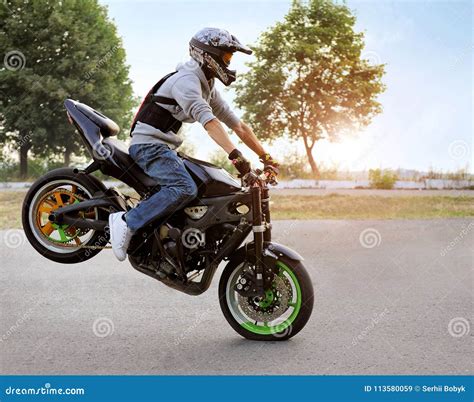 Biker Sitting On Motorcycle On Sunny Street Editorial Stock Image