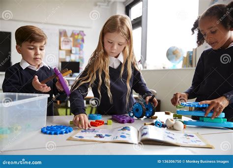 Three Primary School Children Working Together Following An