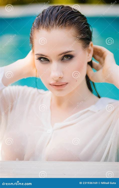 Portrait Of A Beautiful Girl With Wet Hair Dressed In A White Shirt Standing Chest Deep In Water